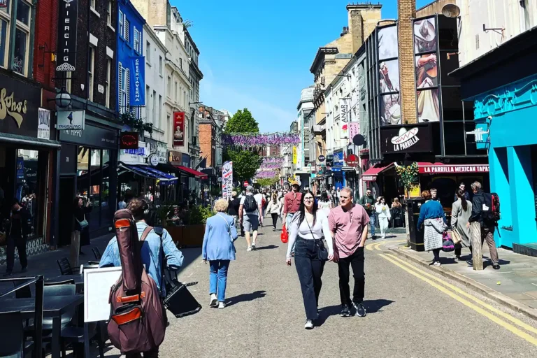 Busy Liverpool street lined with independent restaurants and food venues on a sunny day