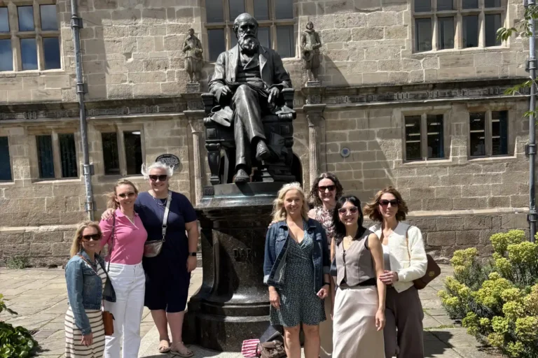 Visitors on a Shrewsbury food tour beside the Charles Darwin statue.